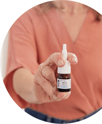 Image of person holding a 4.2 mL bottle of Tyrvaya® (varenicline solution) nasal spray